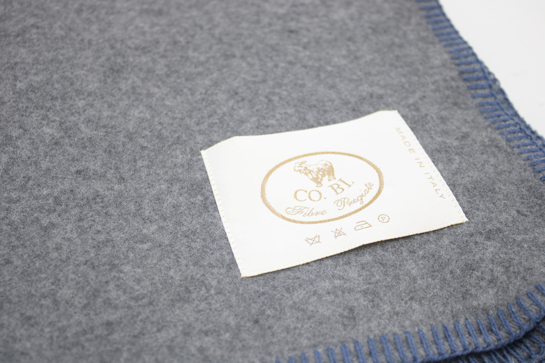 Particolare coperta di misto lana grigio con bordo blu