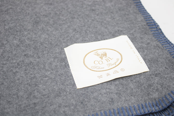 Particolare coperta di misto lana grigio con bordo blu