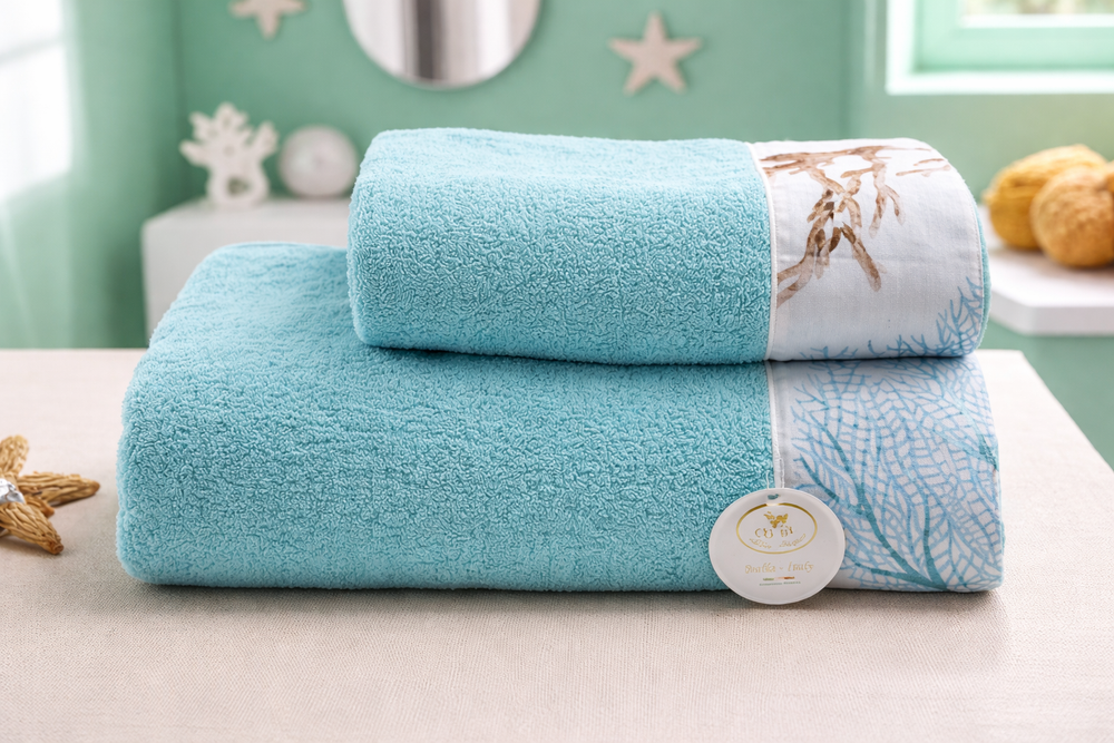 Asciugamani bagno di spugna color turchese con balza disegnata