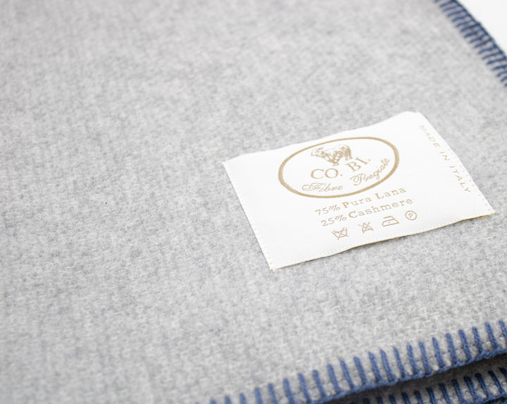 Particolare coperta grigia con bordo blu