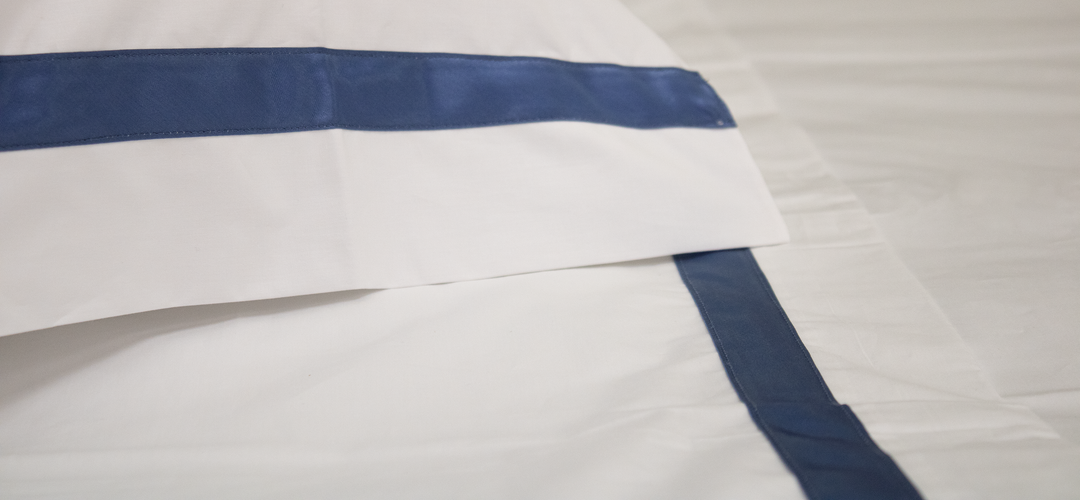 Particolare lenzuolo di percalle con fascia blu scuro