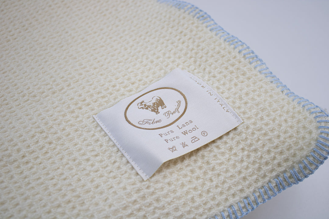 Particolare coperta di lana con bordo a punto cavallo azzurro