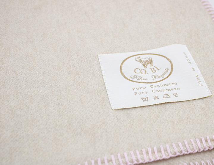 Particolare copertina beige con bordo rosa di cashmere