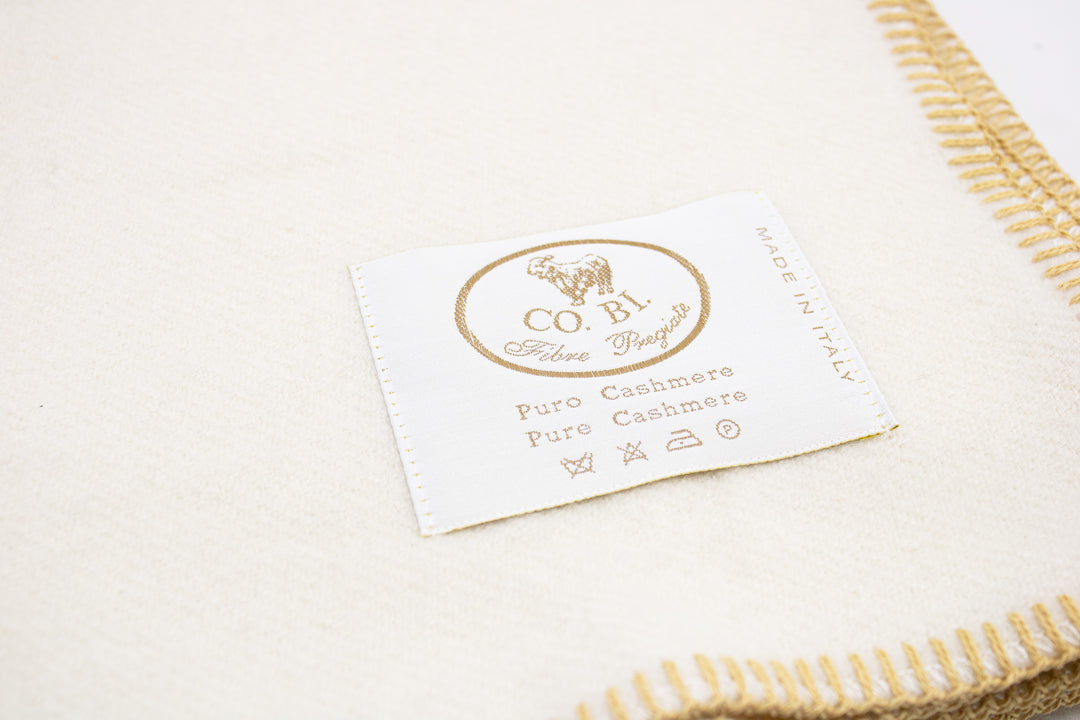 Particolare coperta di cashmere bianca con bordo senape