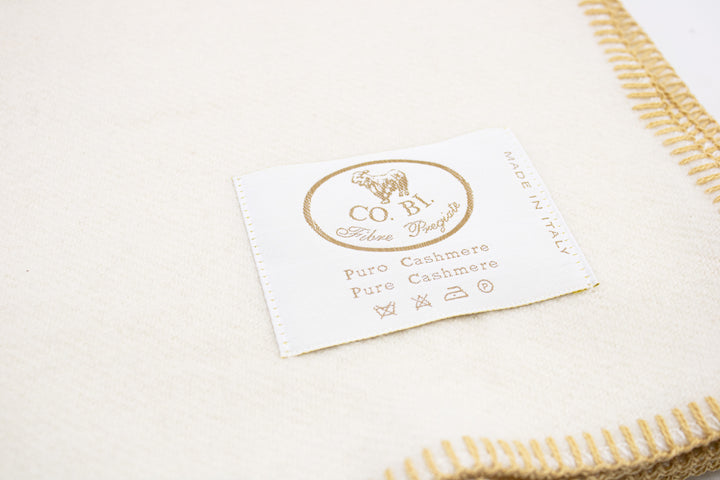 Particolare coperta di cashmere bianca con bordo senape