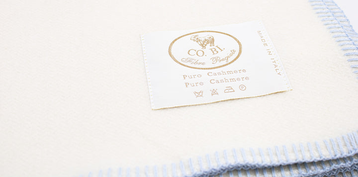 Particolare coperta per culla bianco con bordo azzurro