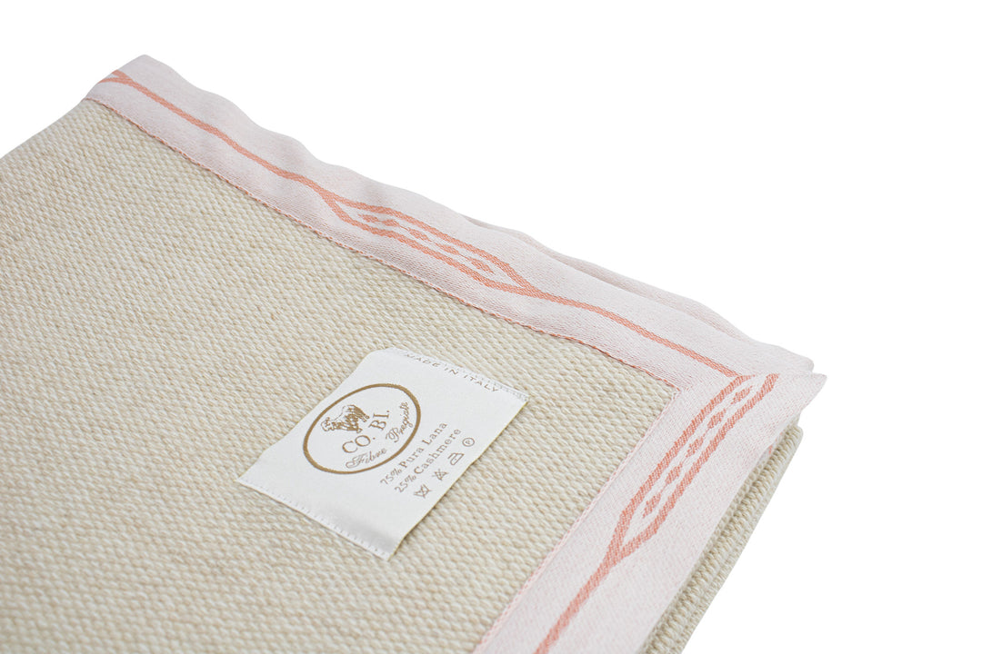 particolare lavorazione della coperta beige con bordo rosa